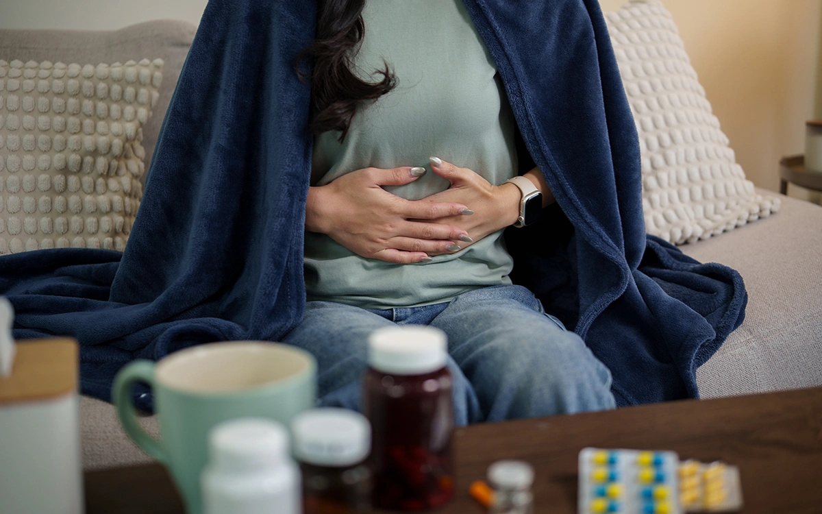 Woman recovering at home, appearing to experience mild discomfort during the recovery period.