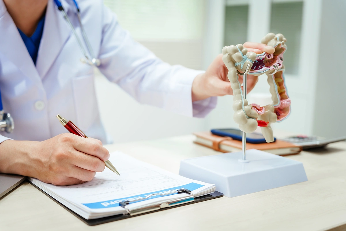 Male doctor reviewing medical records as part of planning for colon surgery.